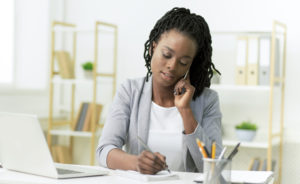 Female Entrepreneur Talking On Cellphone Sitting In Modern Office